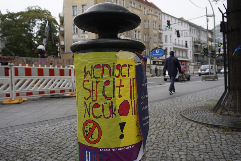 Buntes Plakat auf Hydrant, Ubhf ist im Hintergrund zu sehen