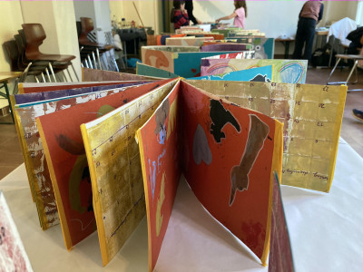 Ein Laporello mit vielen bunten bedruckten Seiten ist kreisförmig aufgestellt.