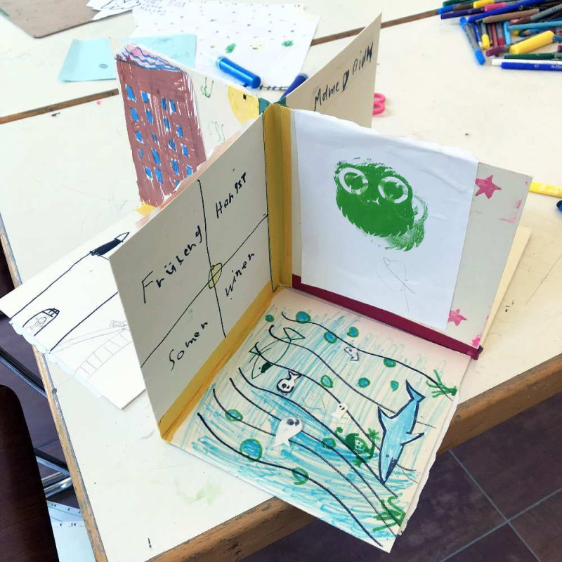 3 D Buch, aufgeklappt, das bunt bedruckt und beklebt ist